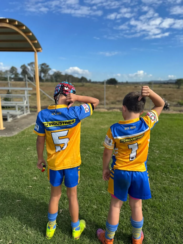 Young rugby players wearing GAP Industries-sponsored jerseys at a local Queensland sports ground, showing community support in action.